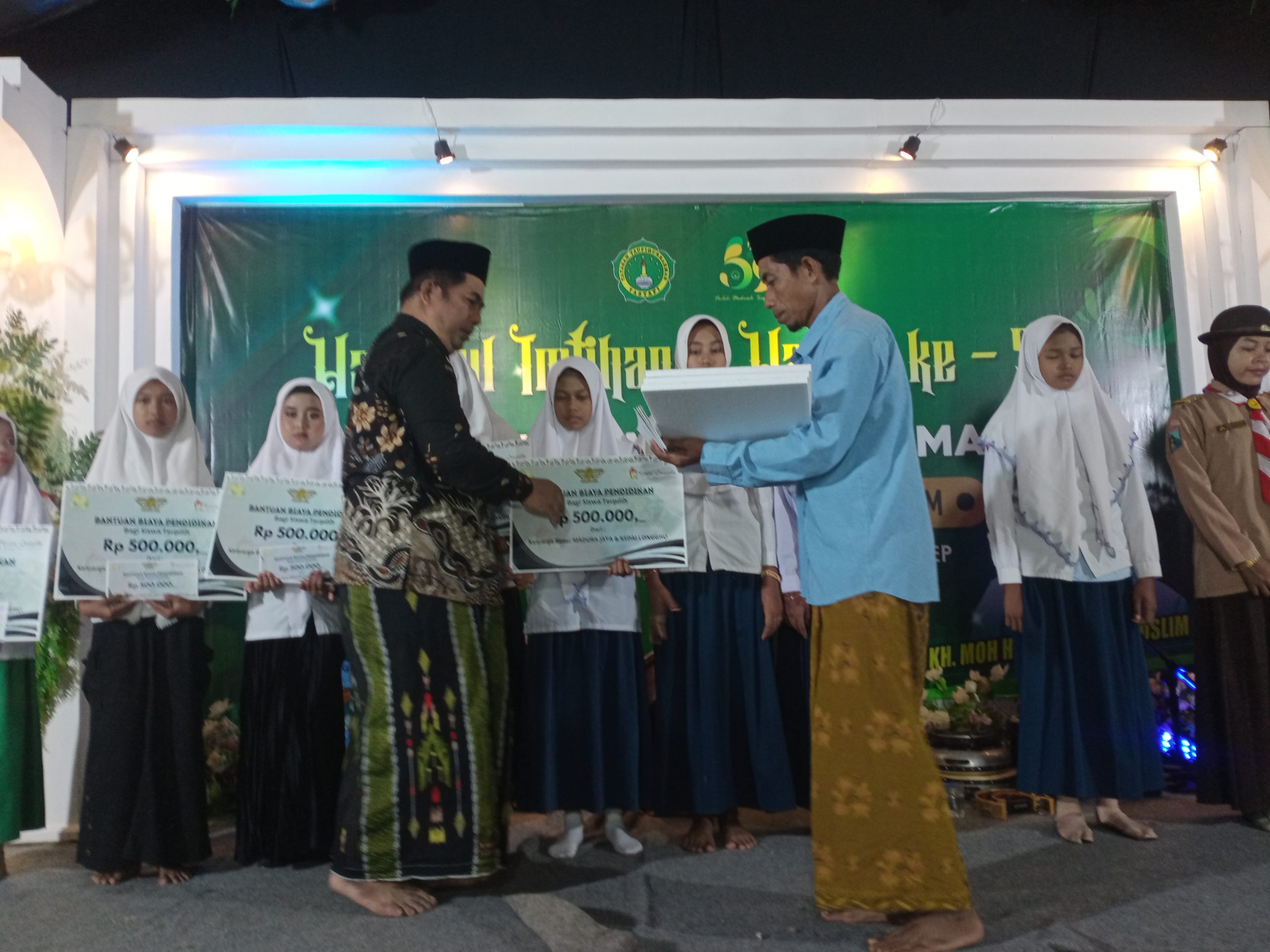 Owner Madura Jaya, Miskawi (pakai batik) saat memberikan bantuan biaya pendidikan kepada siswa berprestasi. Foto: Hokiyanto/AreaNews.id